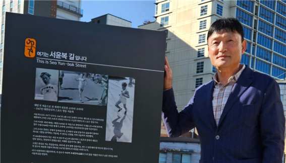 서윤복길 제막식에 참석 후 명판에서 포즈를 취한 김원식 마라톤 해설가 모습.