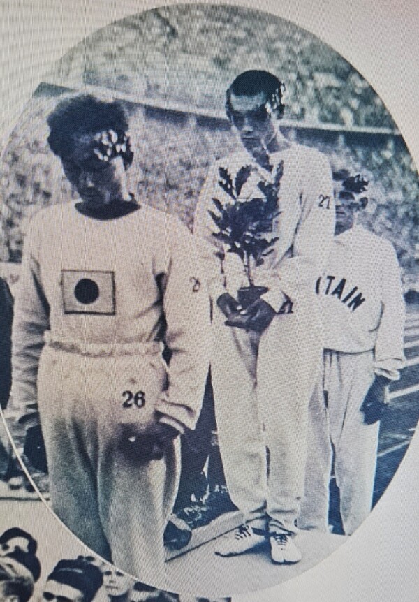 1936년 베를린 올림픽 마라톤 시상대에 선 손기정(사진 가운데), 남승룡(사진 맨 앞) 두 선수가 기뻐하지 못하고 고개를 숙인 슬픈 모습.