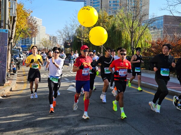 지난 24일 열린 2024 서울 YMCA 마라톤 대회에 출전한 선수들이 노란 풍선의 페이스메이커를 따라 서울 도심을 달리고 있는 모습(사진 출처=필자)